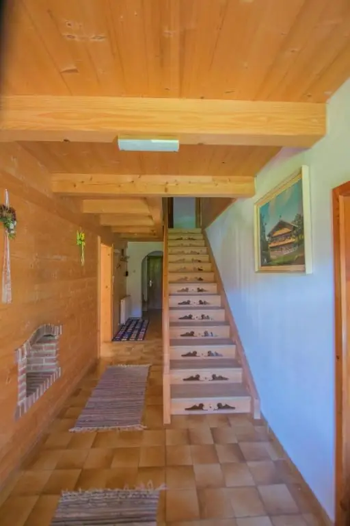 Flur mit Holztreppe in den ersten Stock