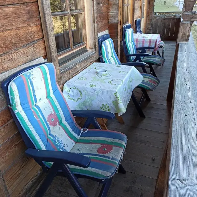 Holzbalkon mit Liegestühlen und Tisch